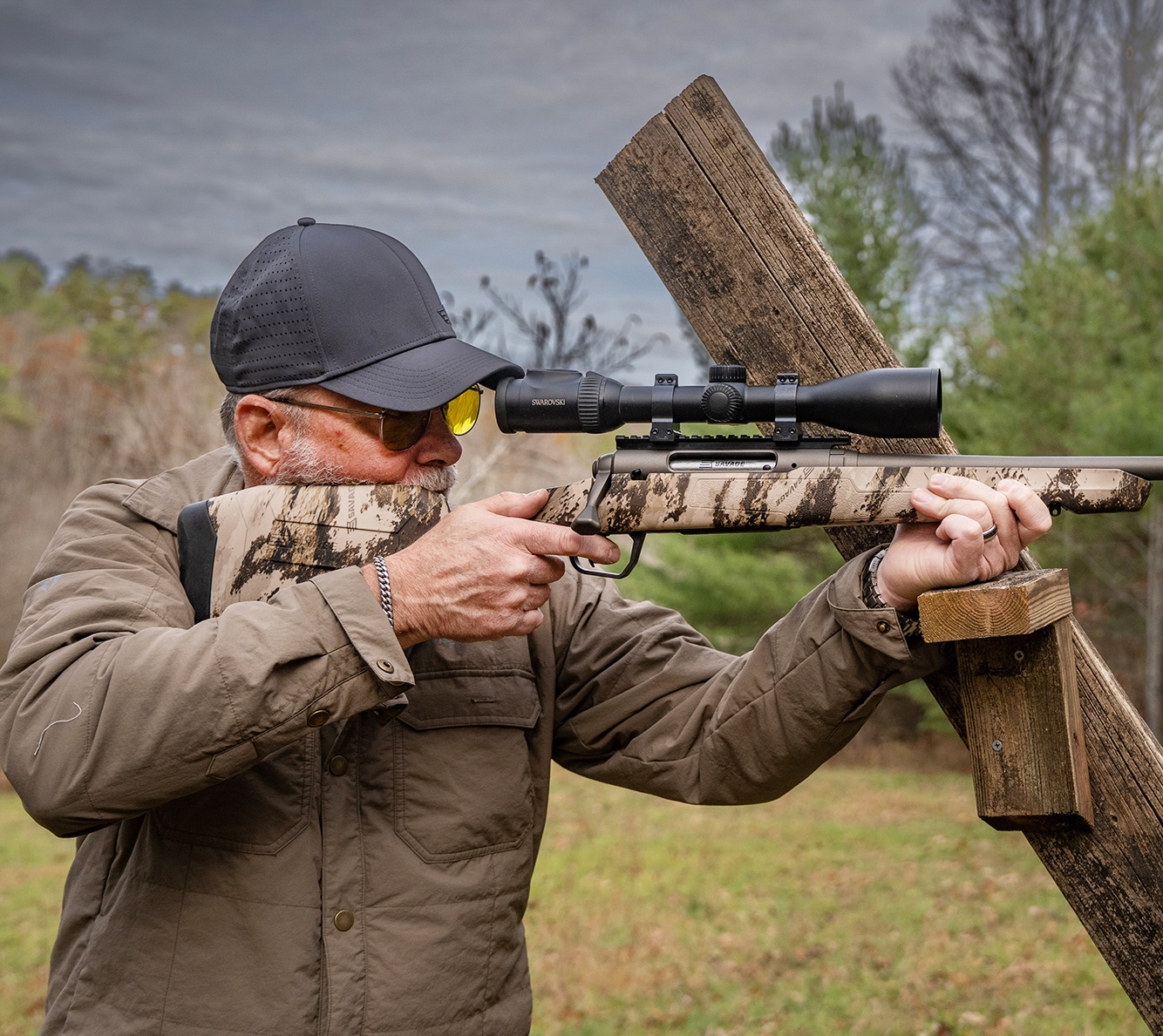 A man shooting for accuracy with a rifle resting on a barricade. 