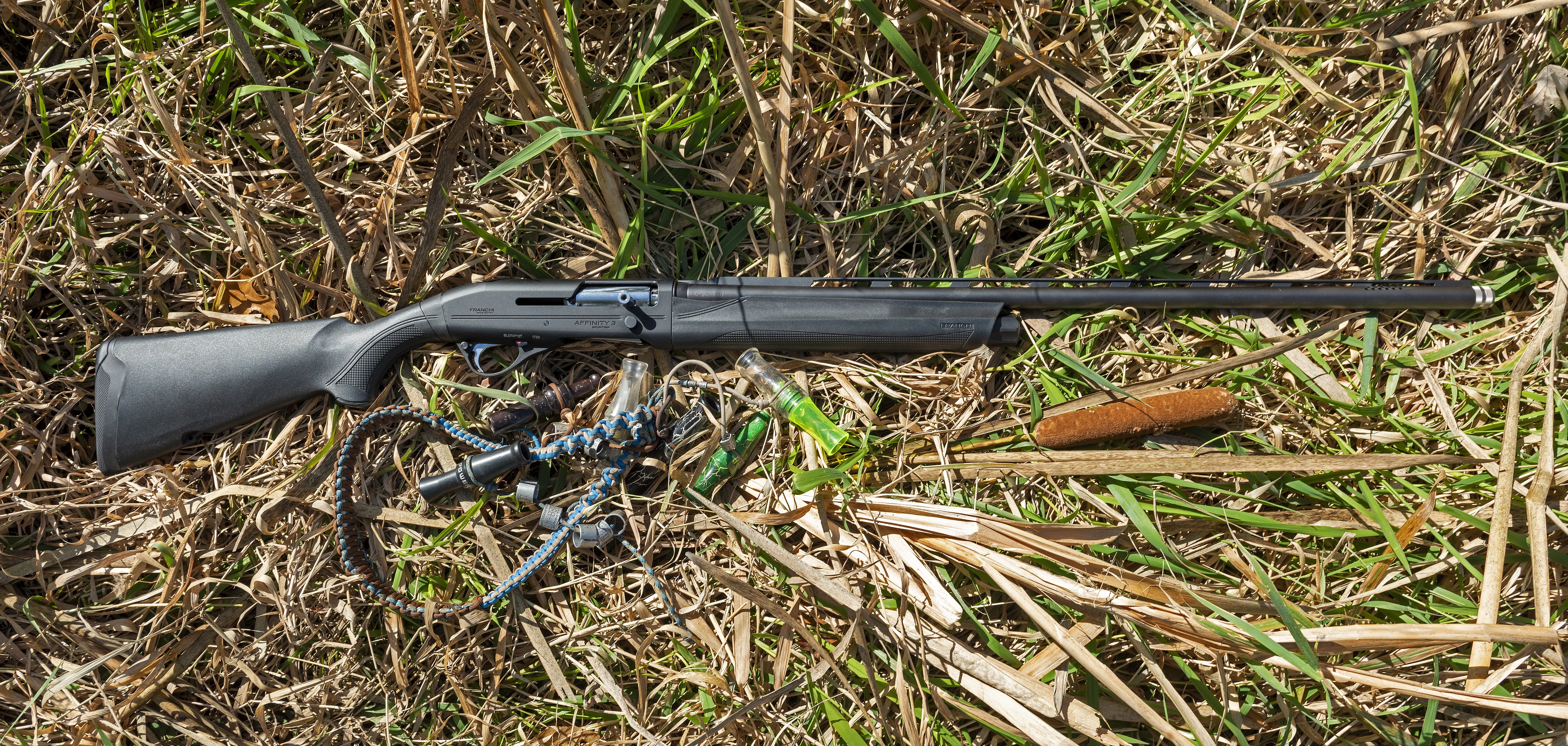 The new Franchi Affinity 3 Sport-Trap shotgun in grass with duck calls.