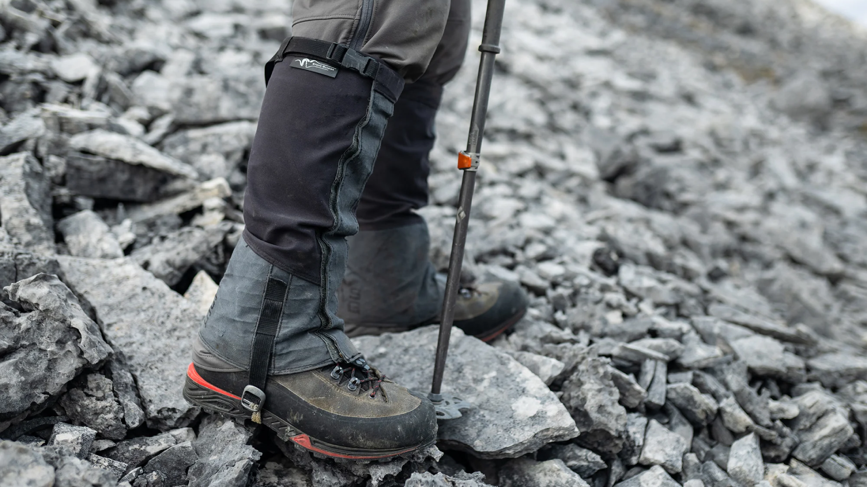 Hunter wearing black Stone Glacier SQ2 Alpine Gaiters on rocks