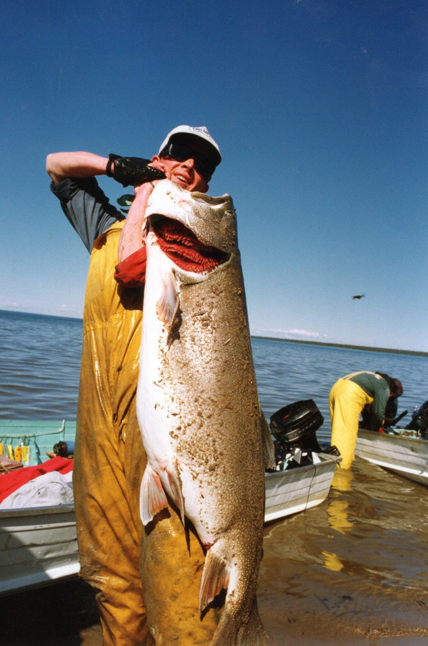 A man holding the biggest lake trout ever caught.