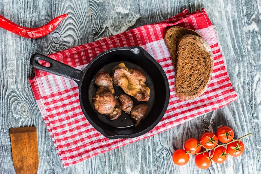 Turkey giblets cooked in a cast-iron skillet on a red-gingham napkin