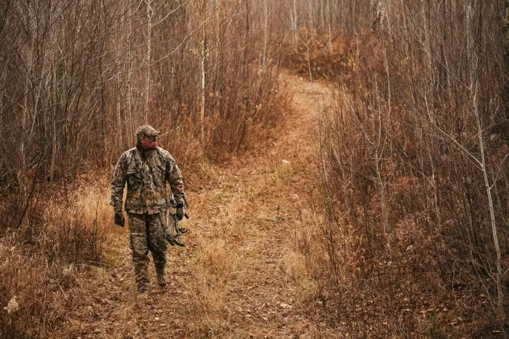 hunter walking on a trail in the woods.