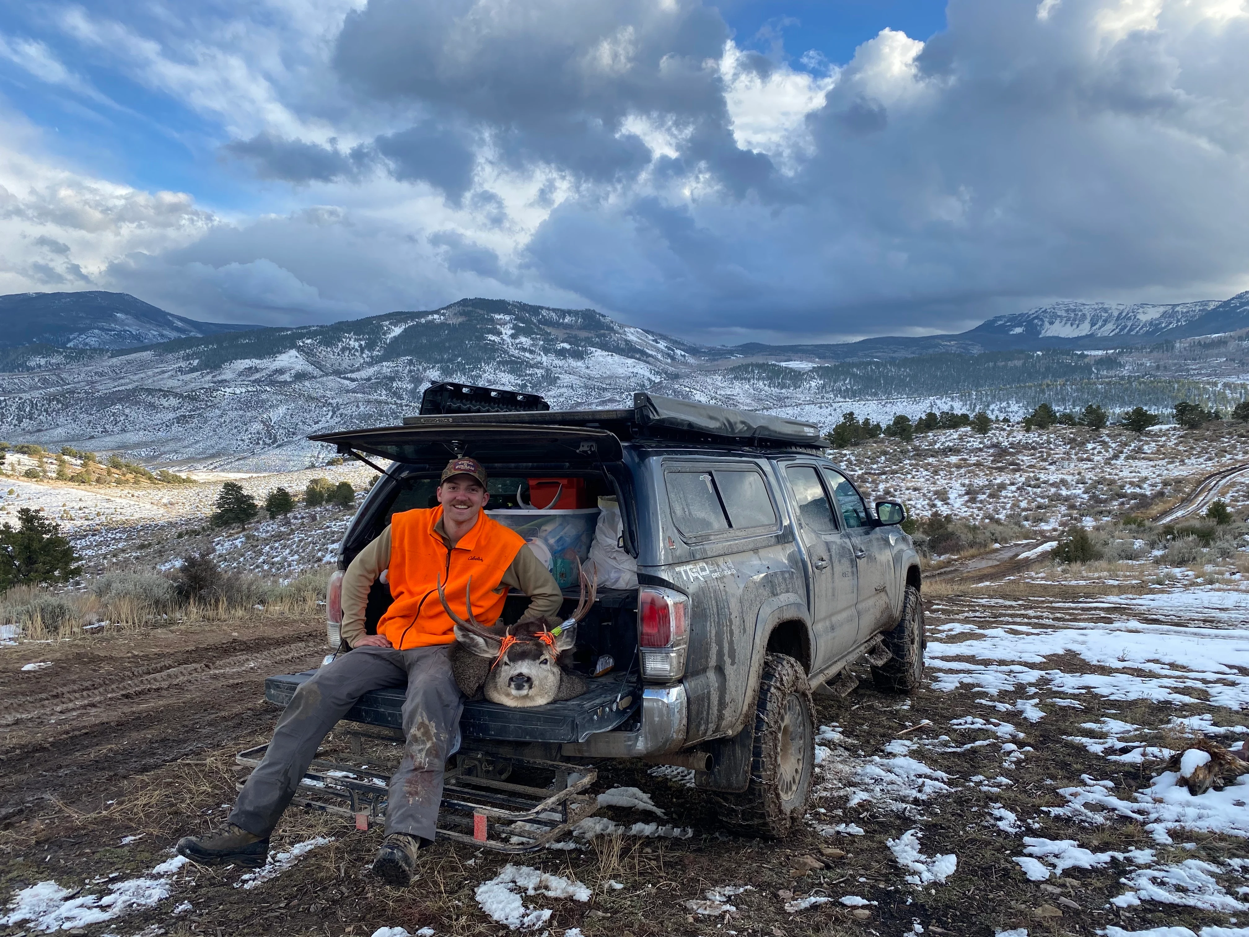 Hunter on tailgate of truck with deer