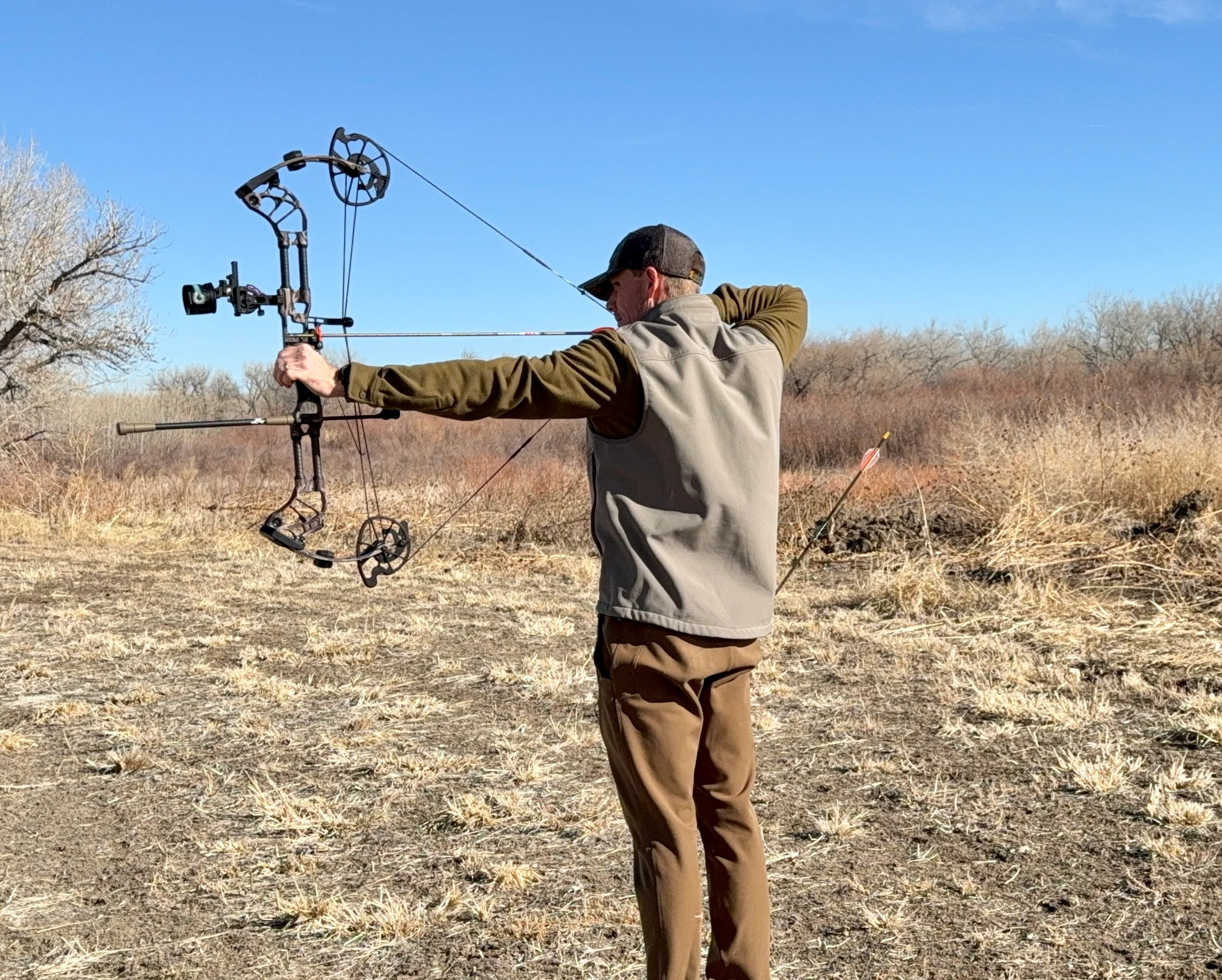 An archer shoots the new Prime Divide compound bow in a field.