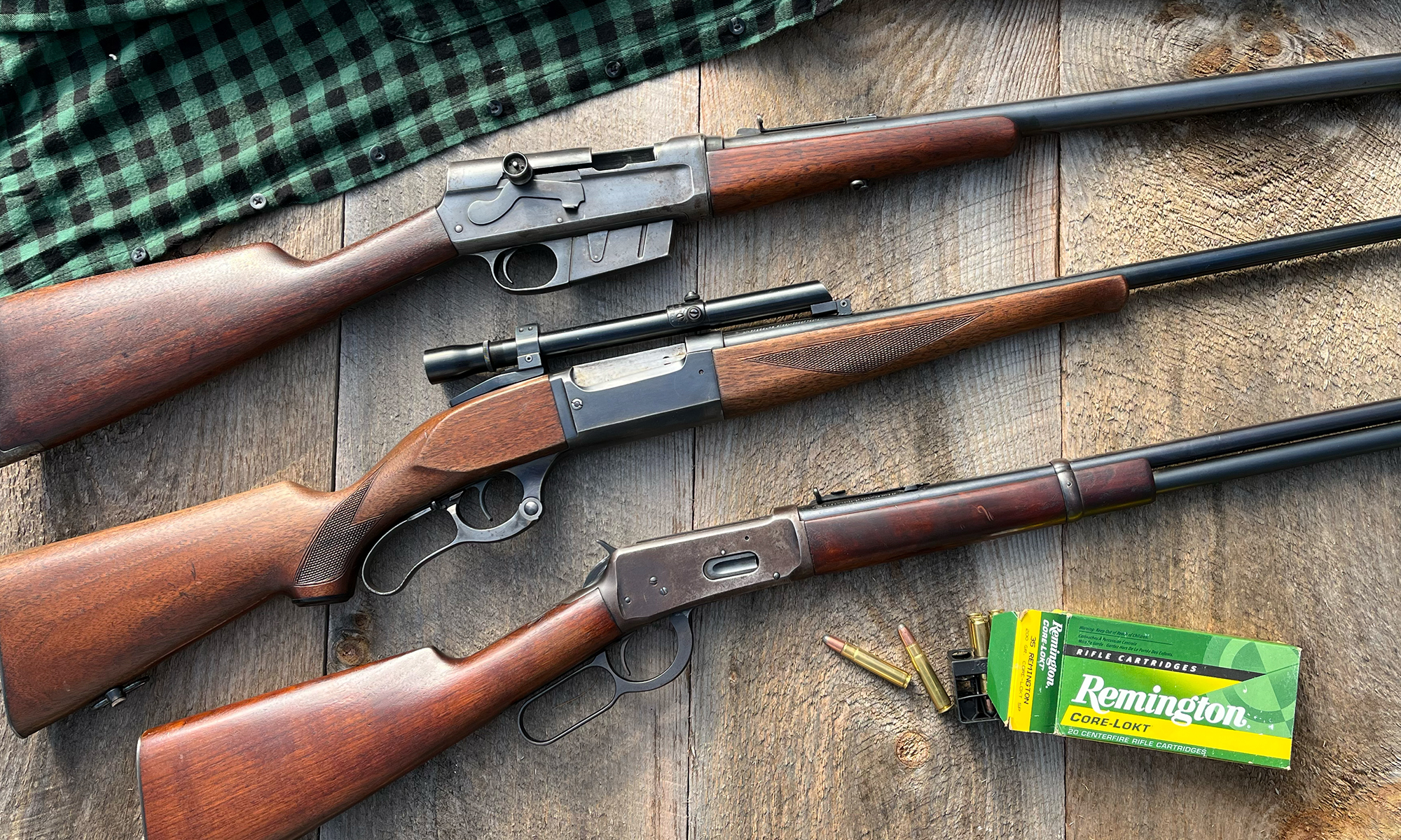 Three classic hunting rifles on a wooden background. 