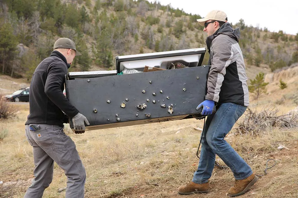 two men carry fridge