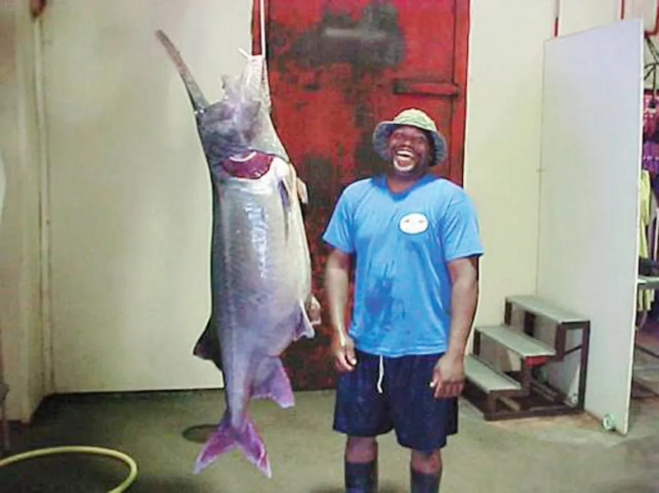 An angler poses with a record-breaking paddlefish in Kansas.