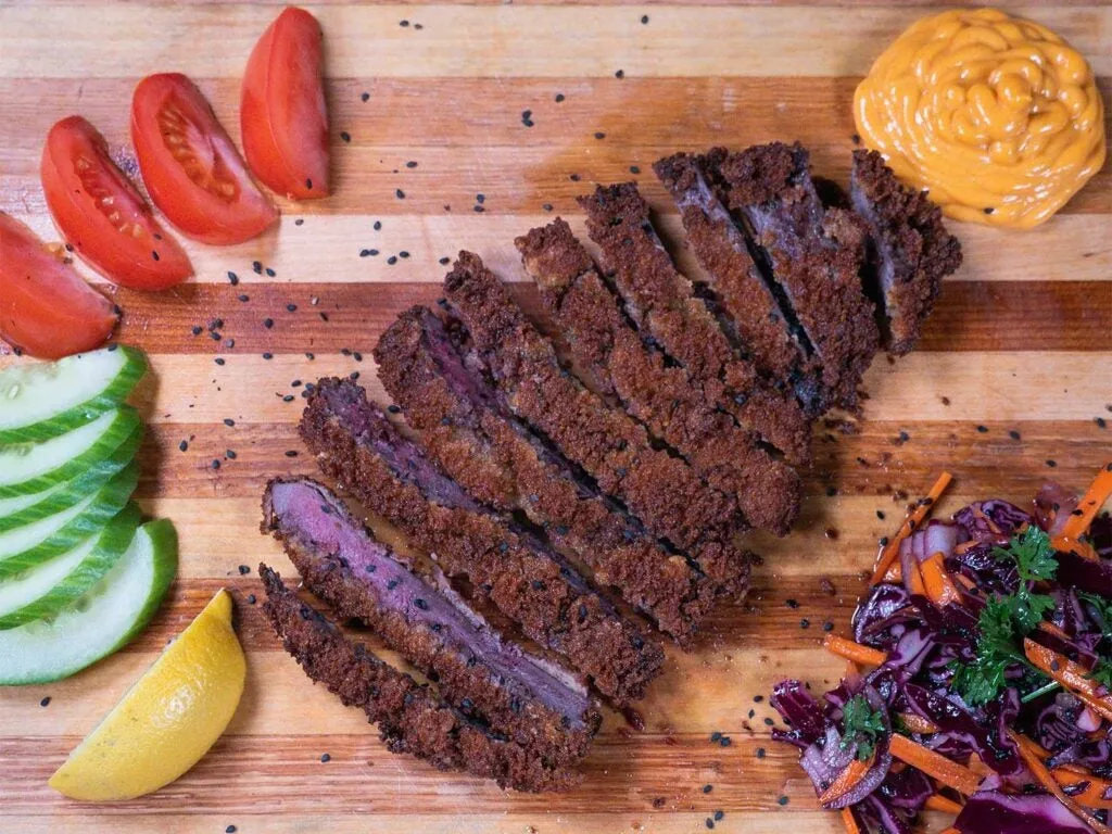 deep-fried venison katsu on a cutting board.