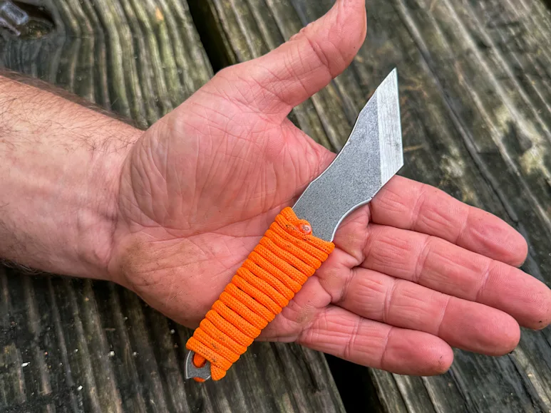 knife handle wrapped in orange parachute cord.