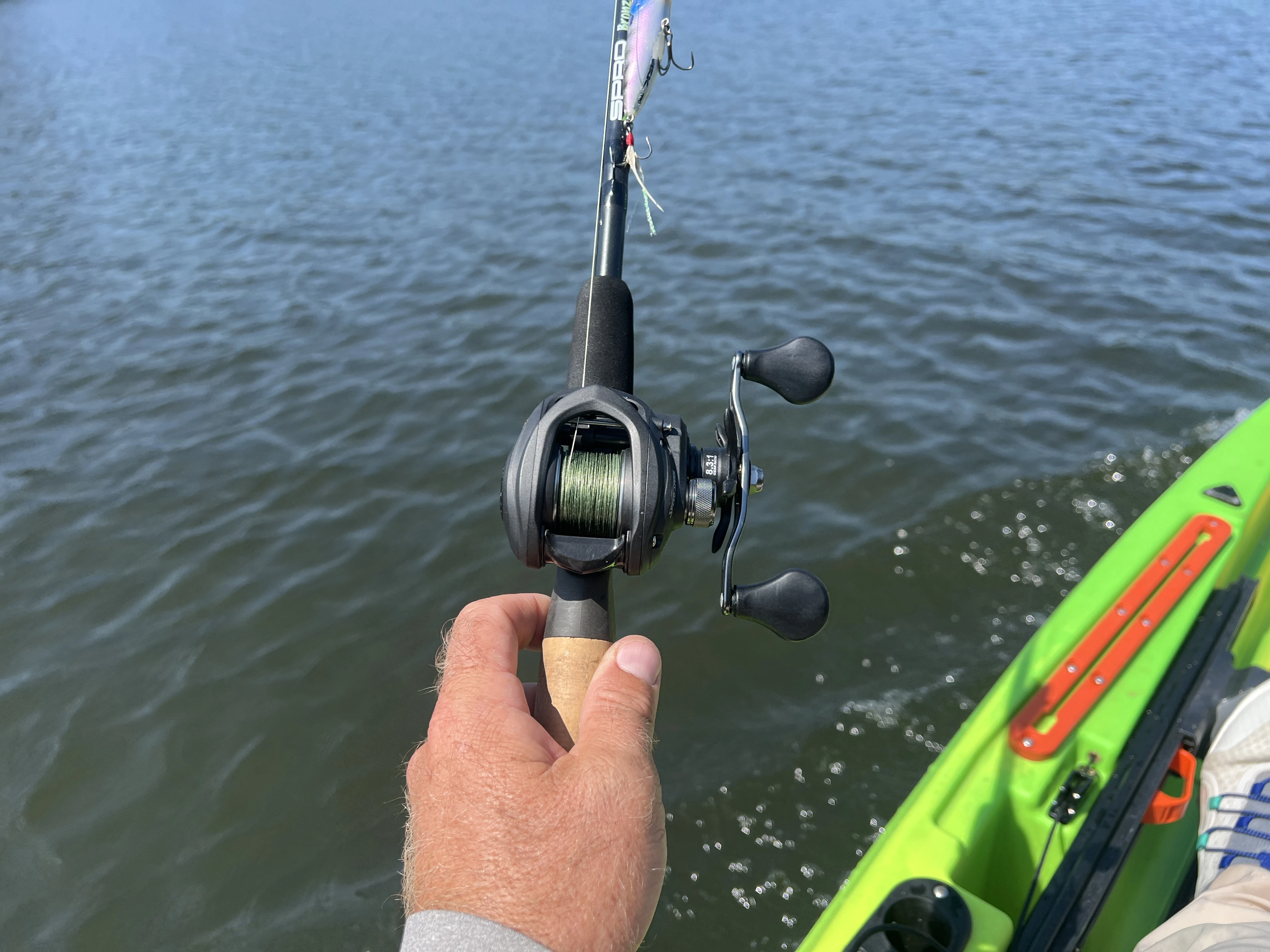 Angler's hand holding Lew's Speed Spool Gen 2 casting reel.