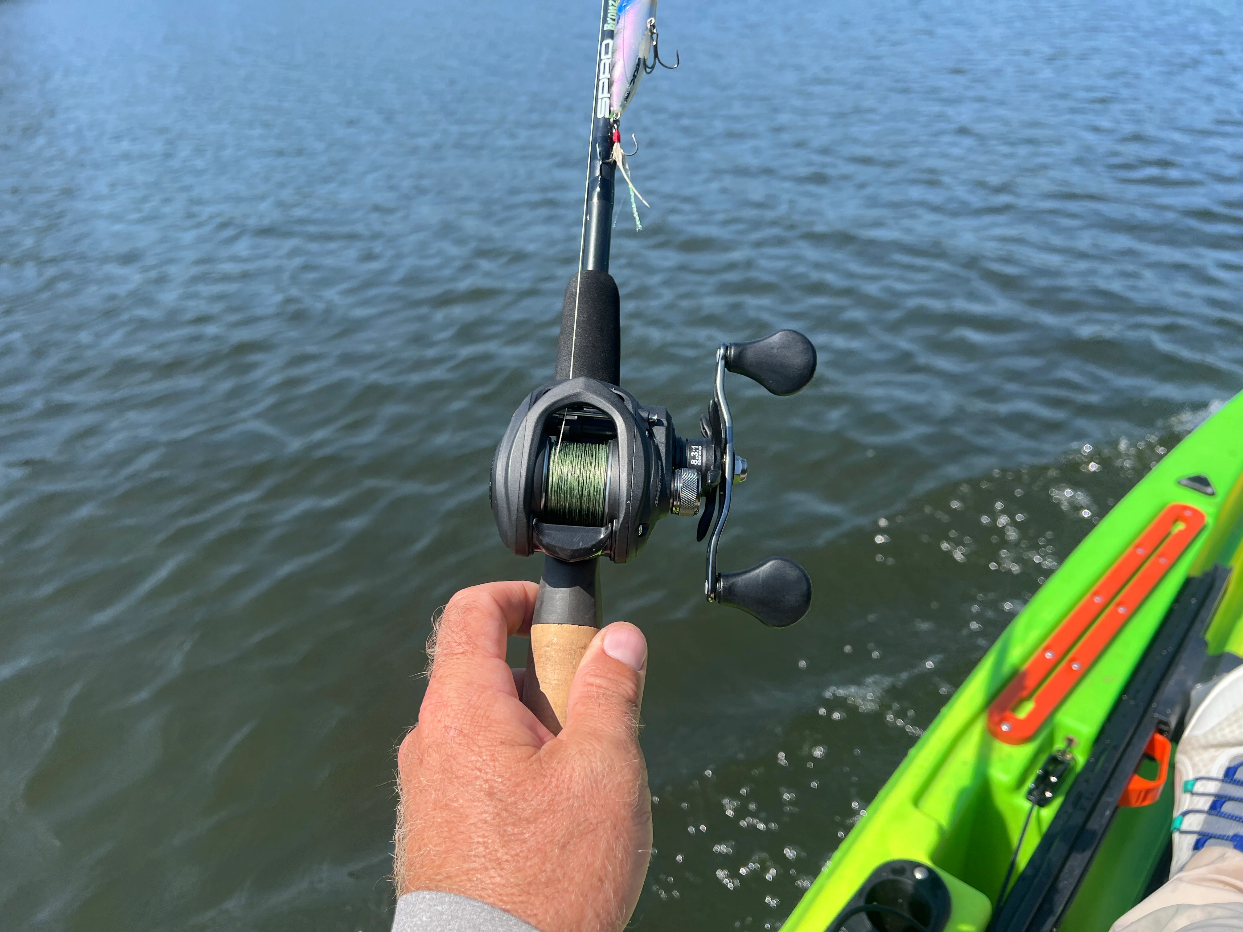 Angler's hand holding Lew's Speed Spool Gen 2 casting reel.