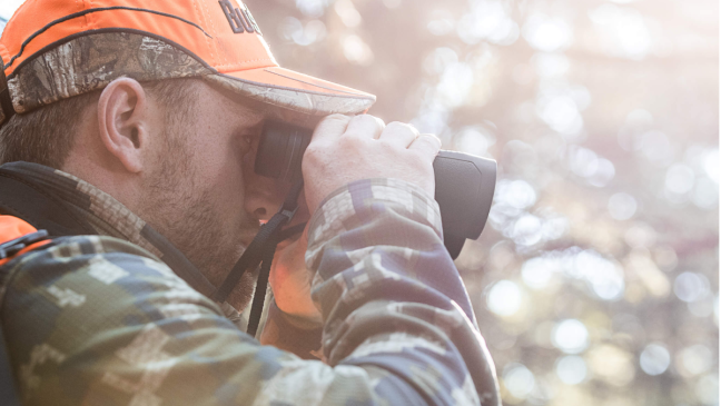 Hunter using a pair of Bushnell Prime hunting binoculars in the field