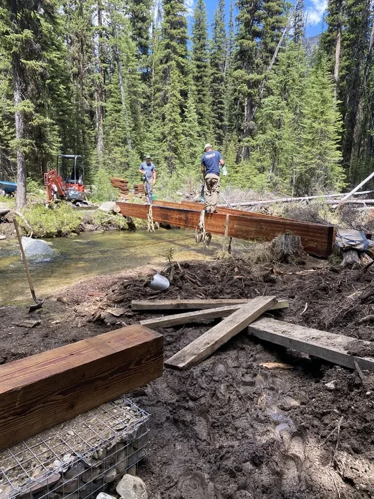 A United State Forest Service crew builds a bridge over a creek in Montana. 