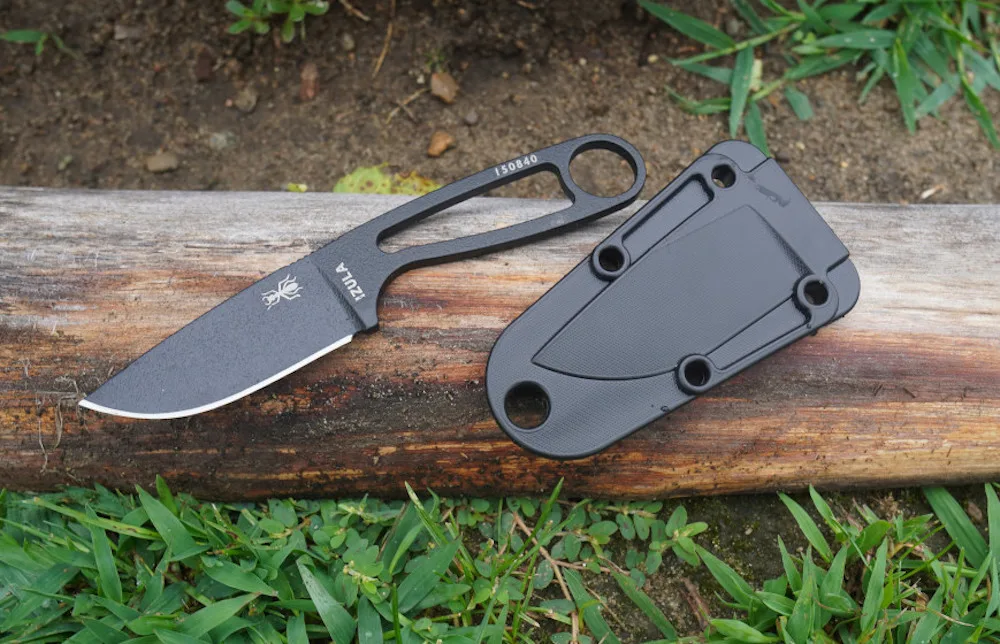 Esee Izula knife laying on grass