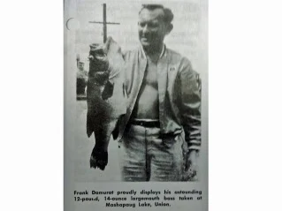 An angler poses with the Connecticut state record for largemouth bass. 