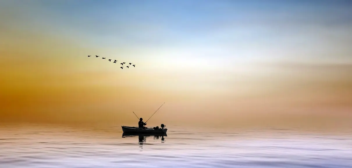 man fishing on a boat in the water