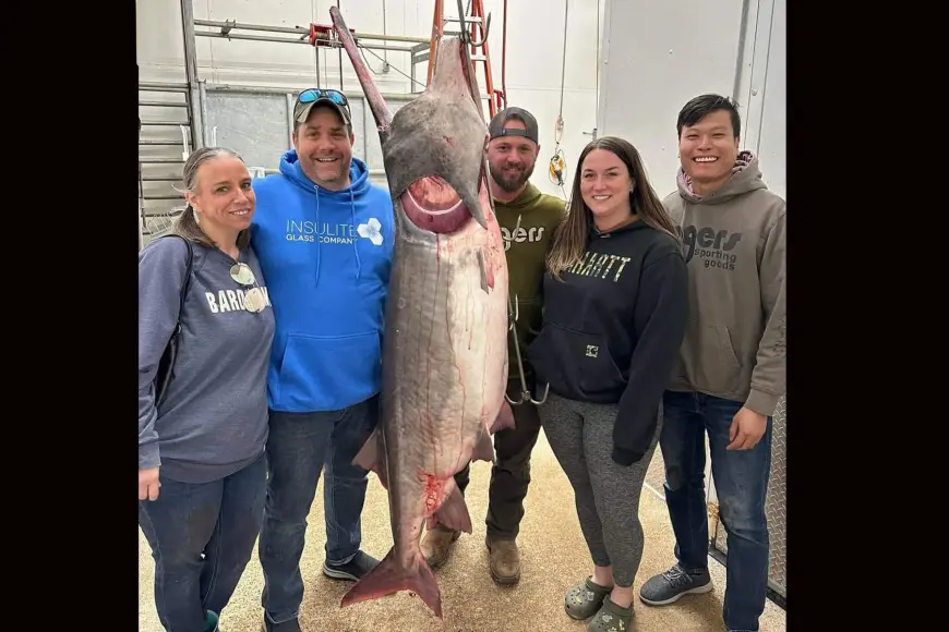 Angler poses with world record paddlefish in Missouri.