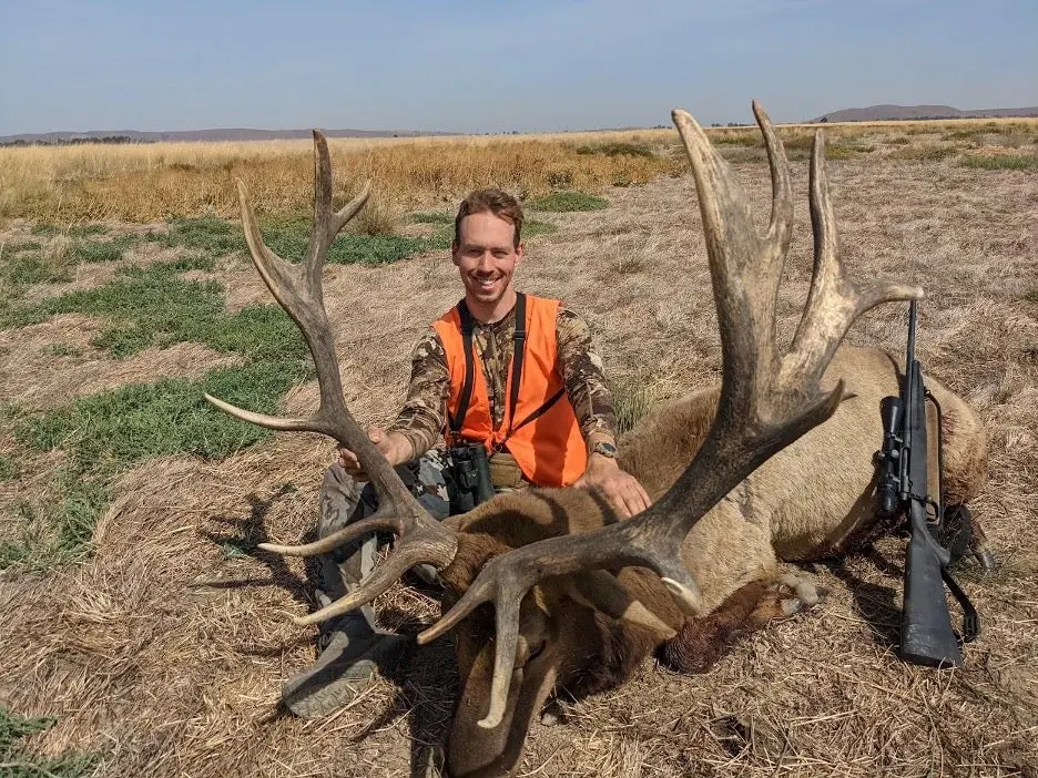 hunter poses with large tule elk