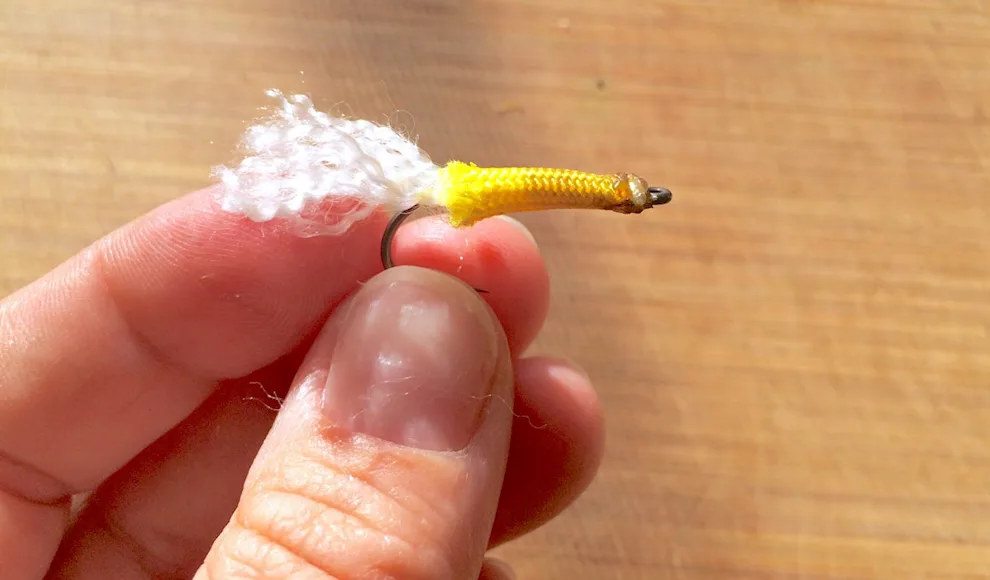 A fisherman holds a lure made from paracord.