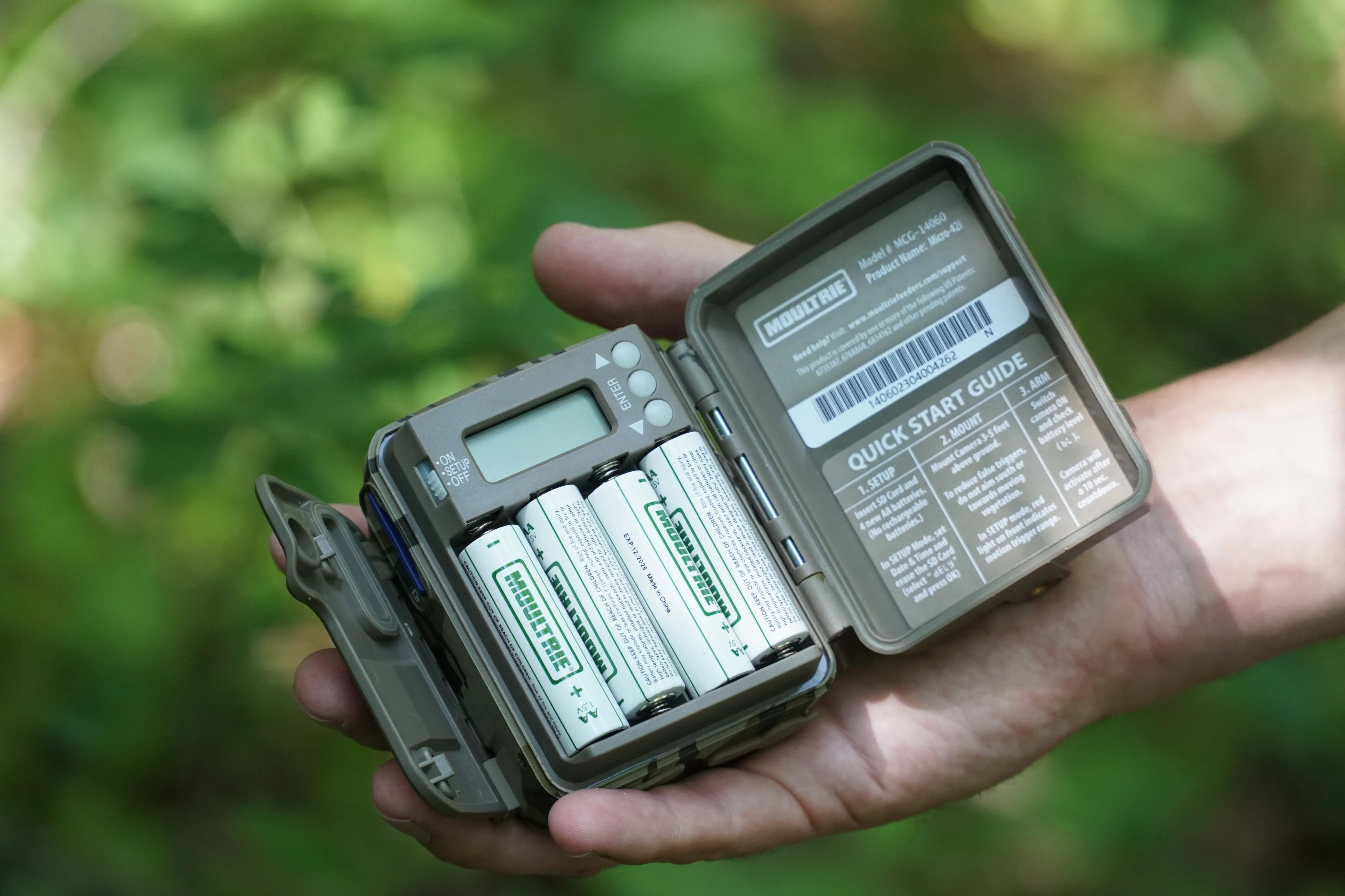 A Moultrie Micro 42-i trail camera in the palm of a man's hand. 