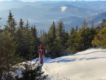 Hiker climbing a snowy mountain, best snowshoes Field & Stream