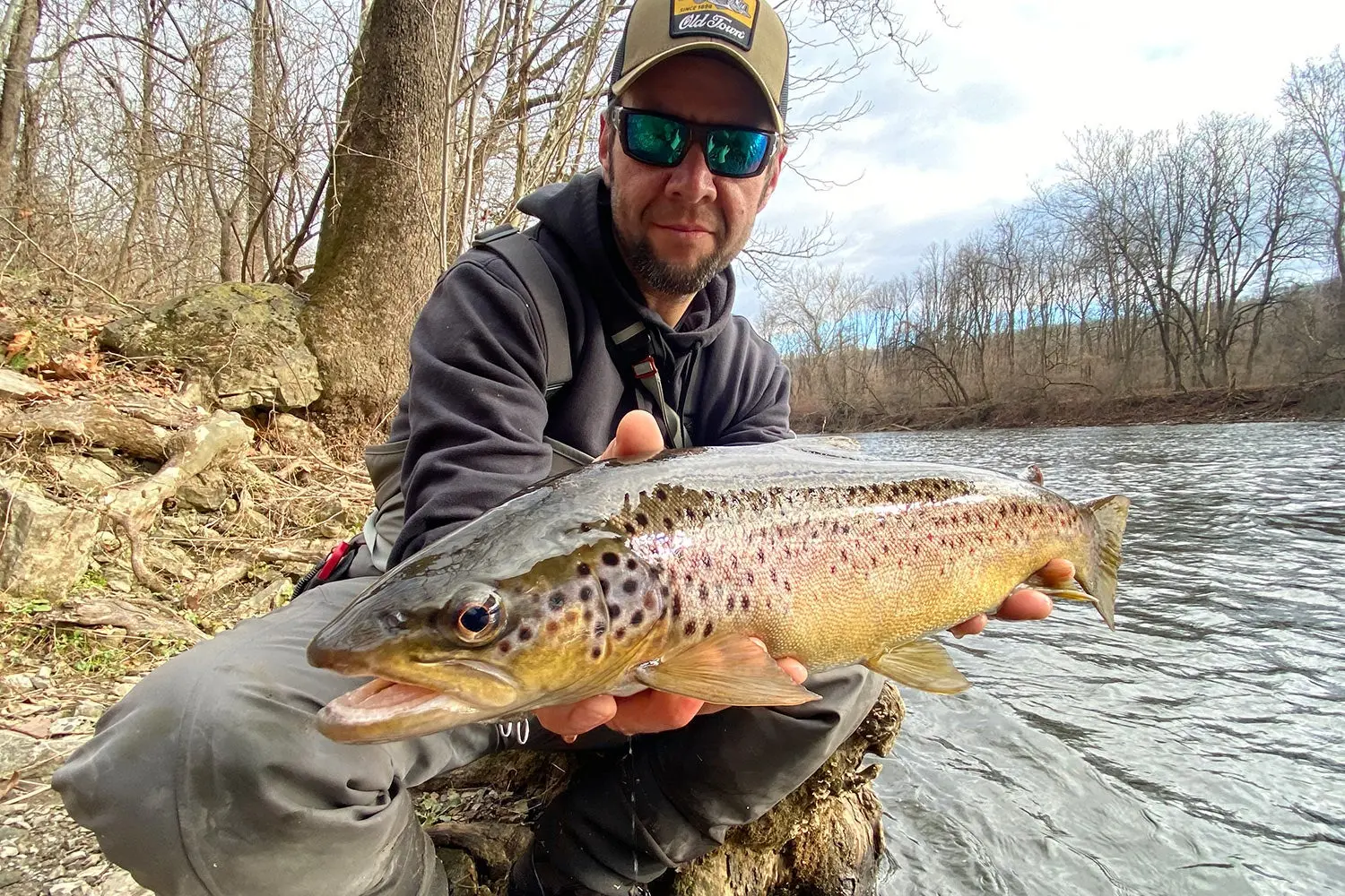 fisherman holds fish out to camera