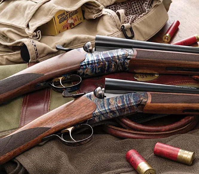 Two shotguns on a hunting jacket and backet.