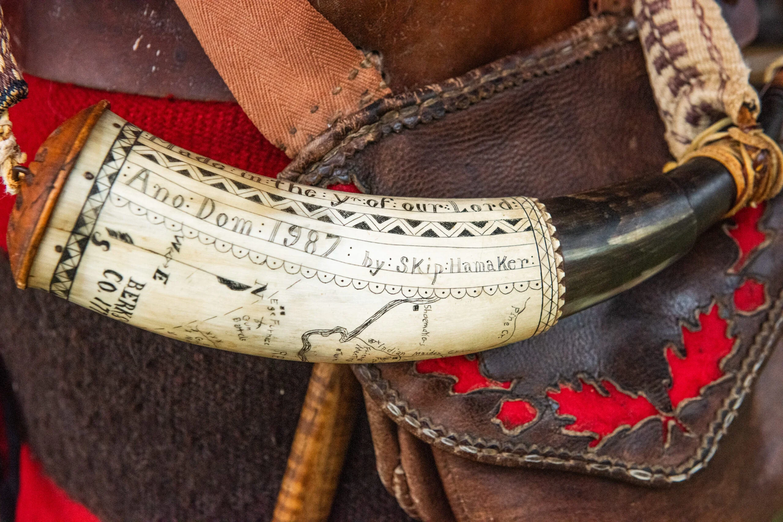 A highly decorated powder horn carried by a traditional flintlock hunter