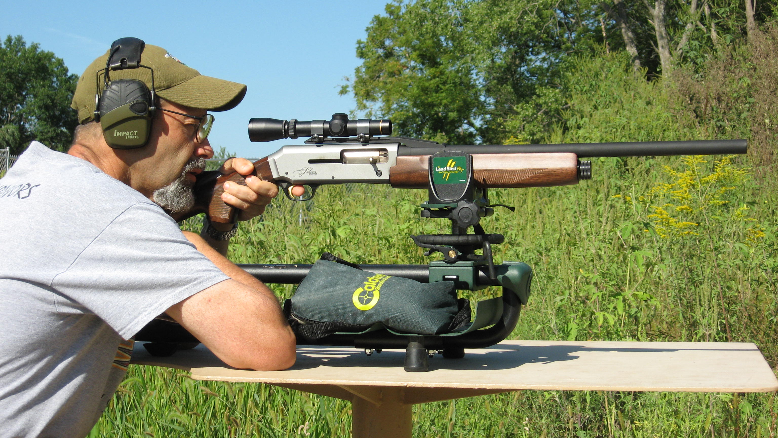 Shooter fires a Browning slug from a bench rest with woods in background