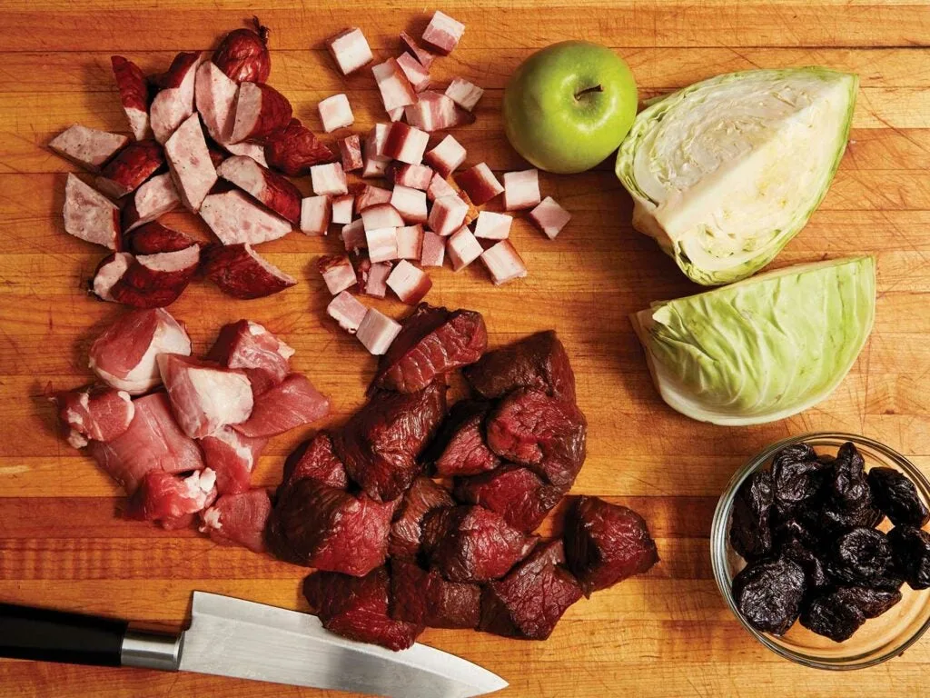 Chopped ingredients for Bigosâa polish venison stew recipeâarranged on a cutting board.