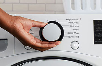 woman hand setting a washing machine knob