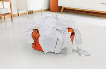 large basin full of dirty clothes on bathroom floor