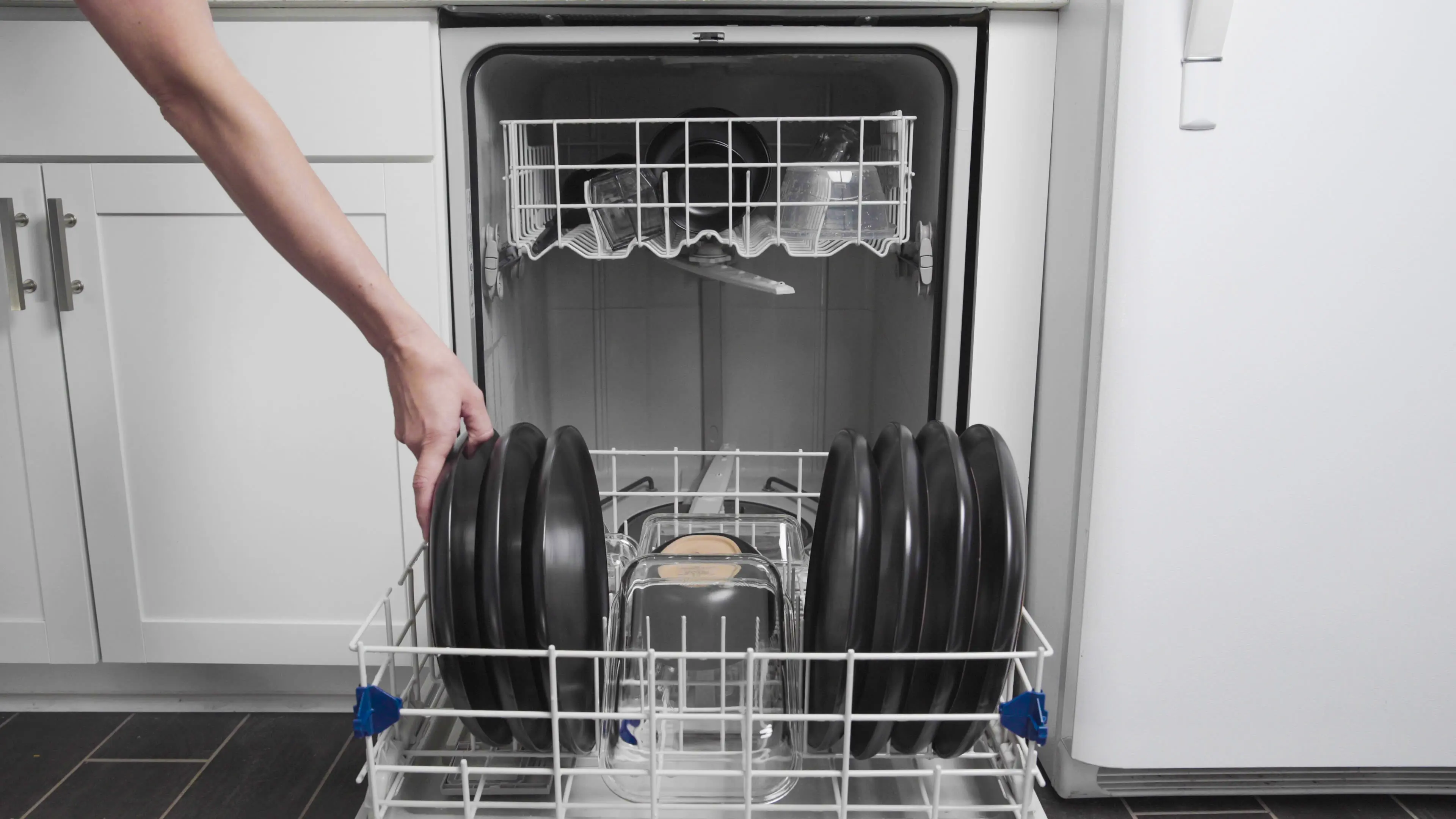 Showing how to load a dishwasher to wash efficiently 
