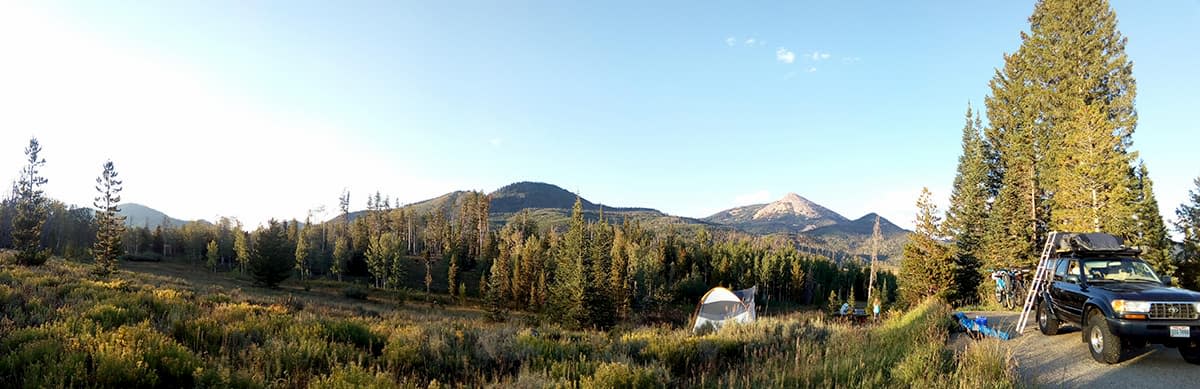 Campground campsite in the Rocky Mountains with tent being pitched