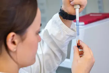 vet holding a syringe for laboratory test