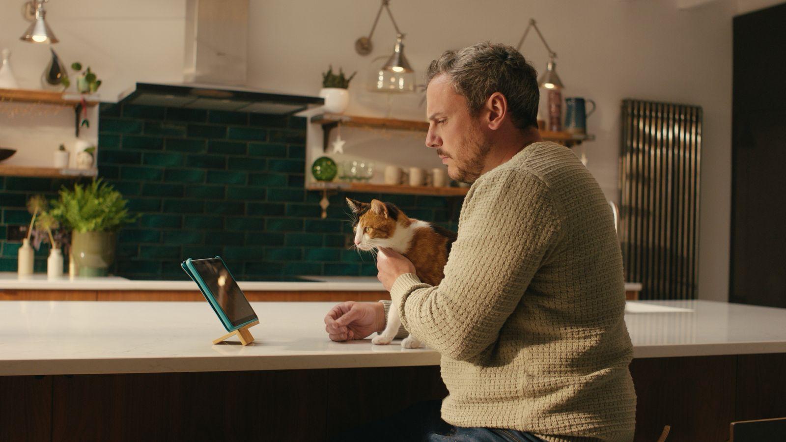 man sitting on counter with cat