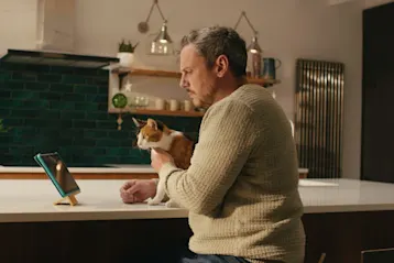man sitting on counter with cat