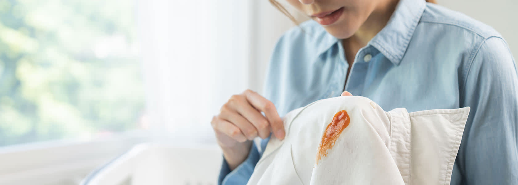 Como-quitar-manchas-de-aceite-en-la-ropa Un hombre con su camisa blanca manchada junto a un plato de comid