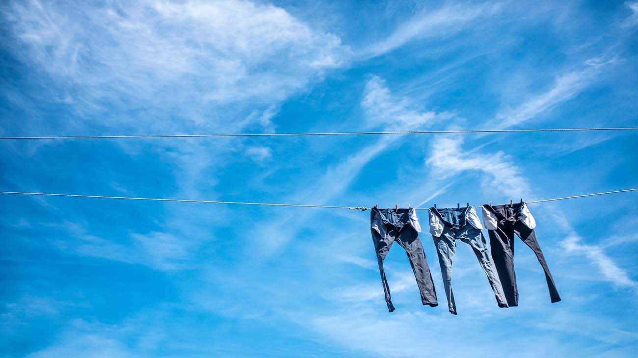 Un hombre revisando el bolsisllo de su pantalón amarronado