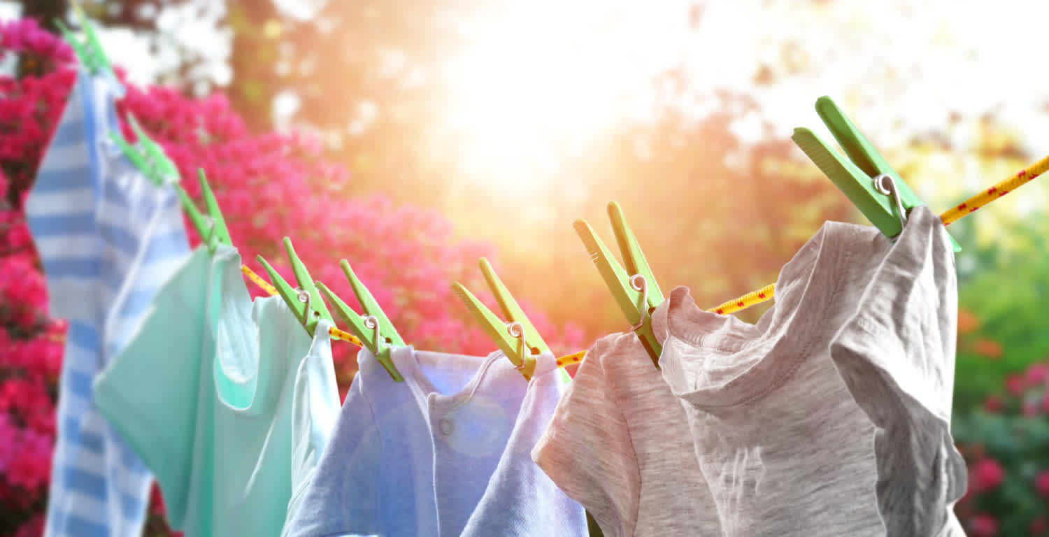 Remeras de colores colgadas con broches seca ndose al sol