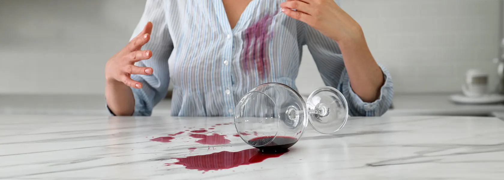 Como-quitar-manchas-de-vino Un hombre sosteniendo una copa de vino con su camisa manchada