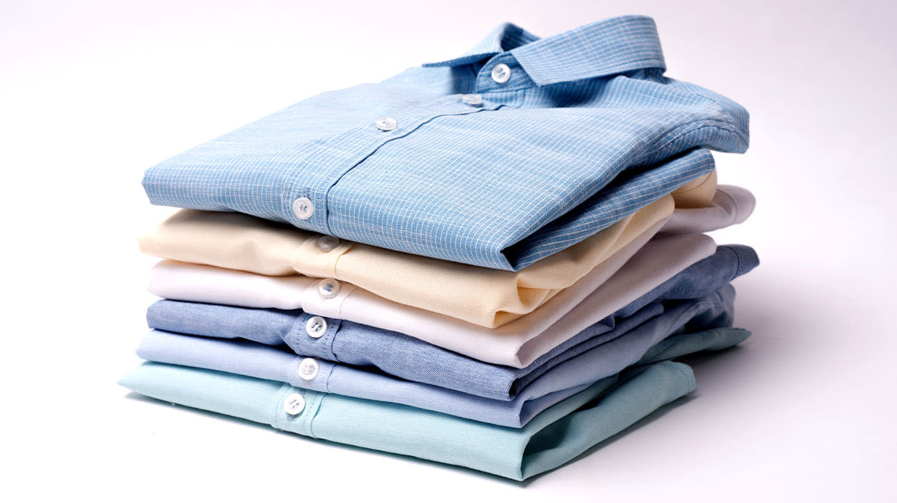 Una pila de camisas apiladas sobre un fondo claro.