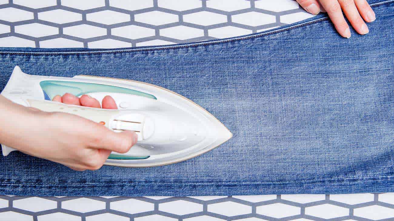 Un jean sobre una superficie estampada siendo planchado.