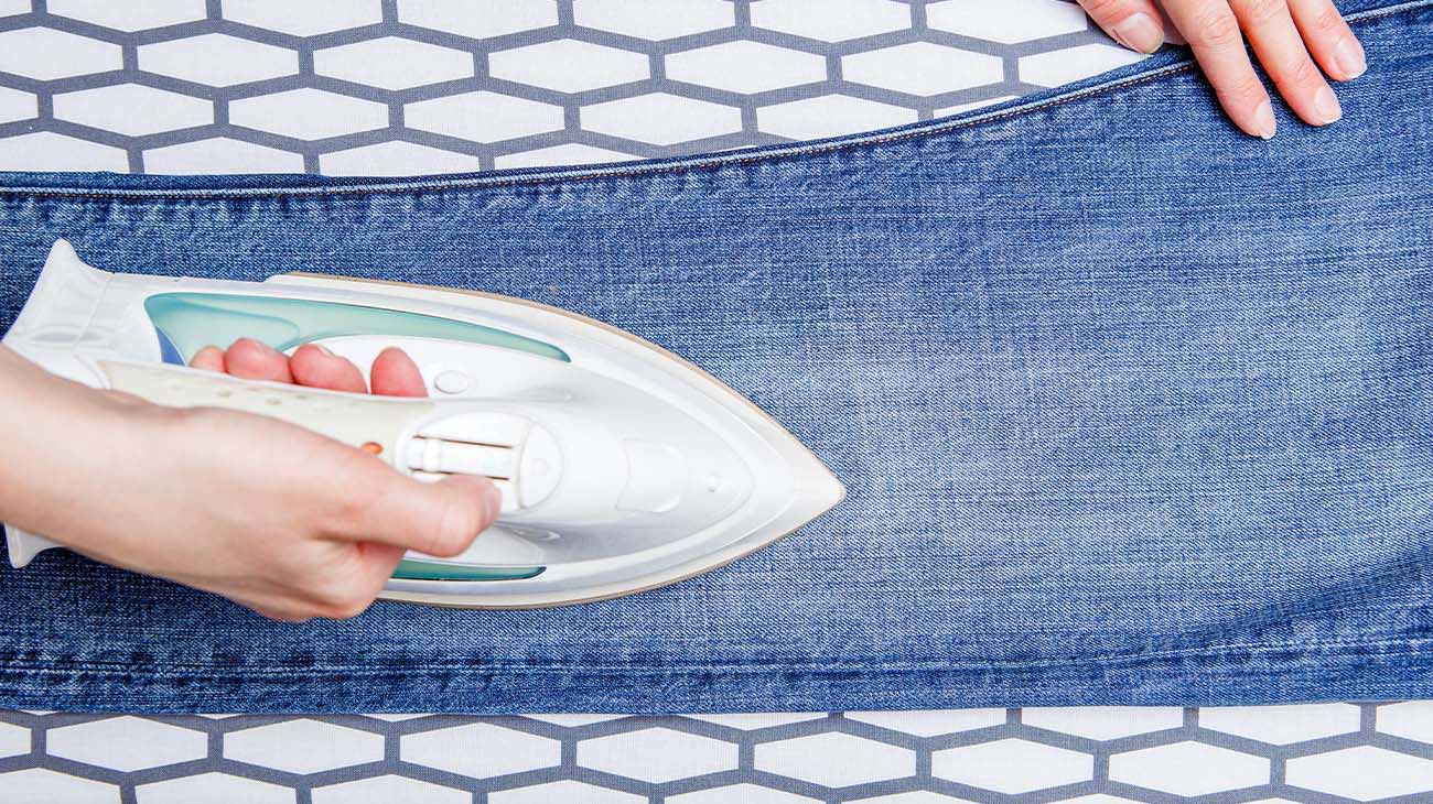 Un jean sobre una superficie estampada siendo planchado.