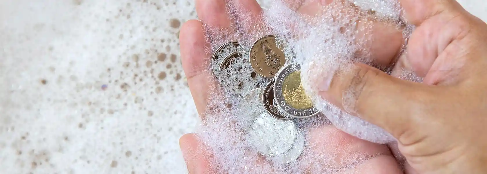 Monedas antiguas de colección en un portafolio junto a una lupa