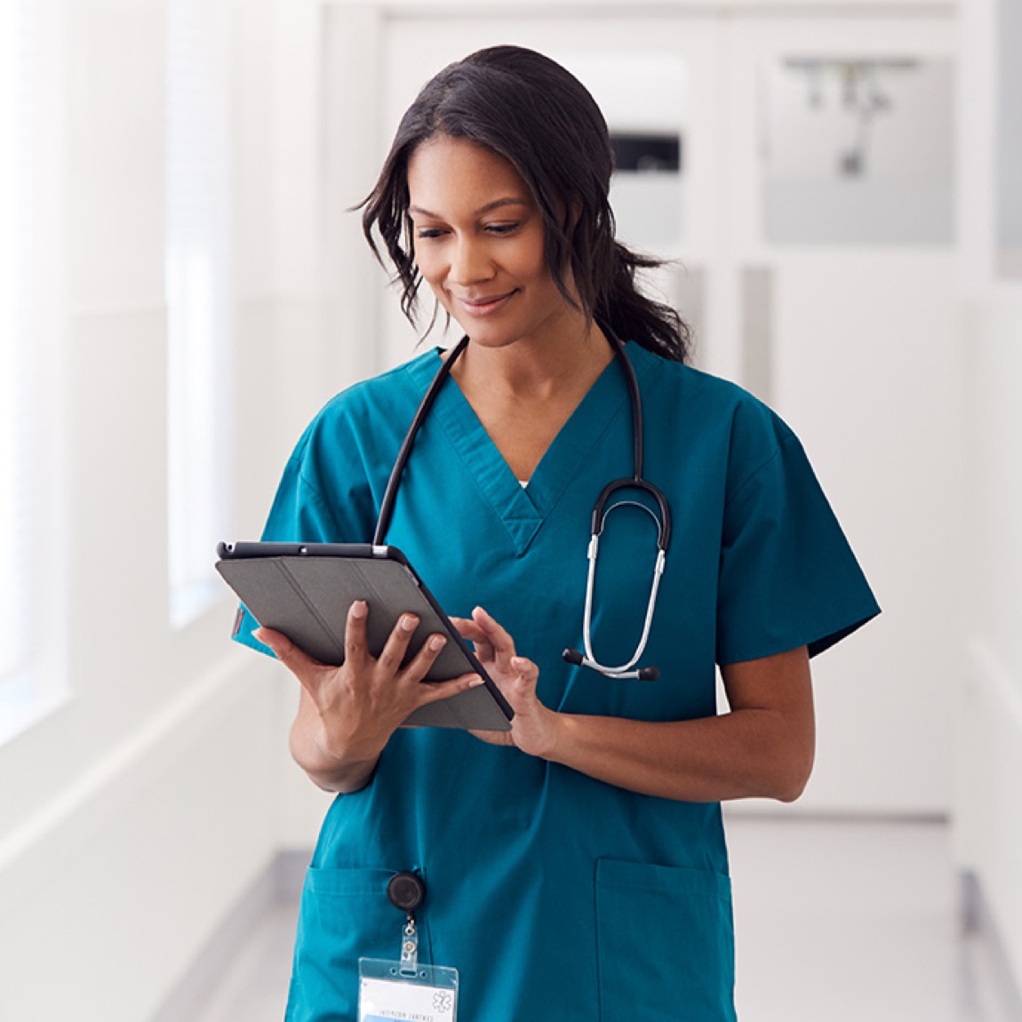 A female nurse viewing information on a tablet.