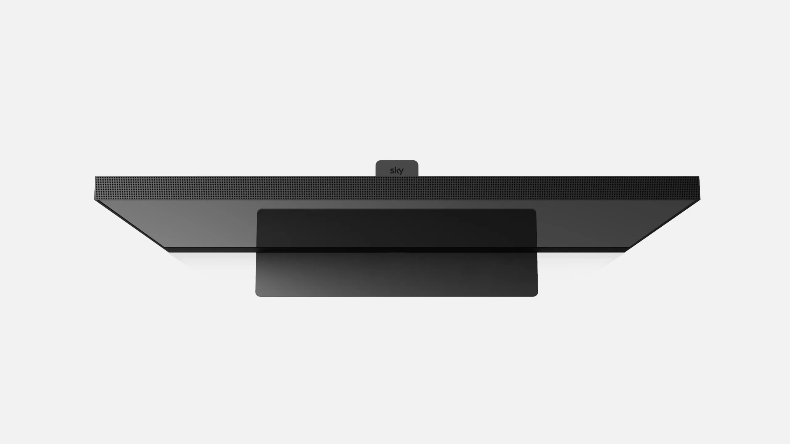 A flat-screen television viewed from above against a white background, showing the top edge, a central black stand, and a small rectangular device labeled Sky attached at the top.