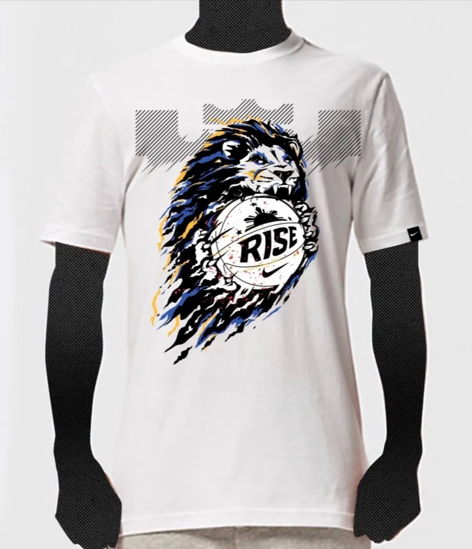 A white t-shirt featuring a graphic of a lion holding a basketball with the word RISE on it. The lions mane is dynamic, with blue, black, and yellow streaks, and a crown-like shape appears above its head.