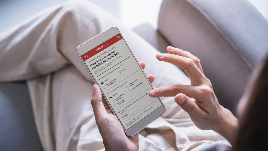 A person lounging on a sofa uses a smartphone to fill out an online survey titled How much should my stimulus pay payment be? displayed on the screen.