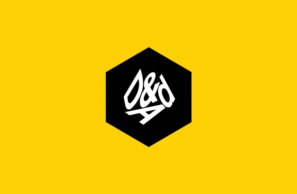 A black hexagon with white stylized “D&AD” text in the center, set against a bright yellow background.